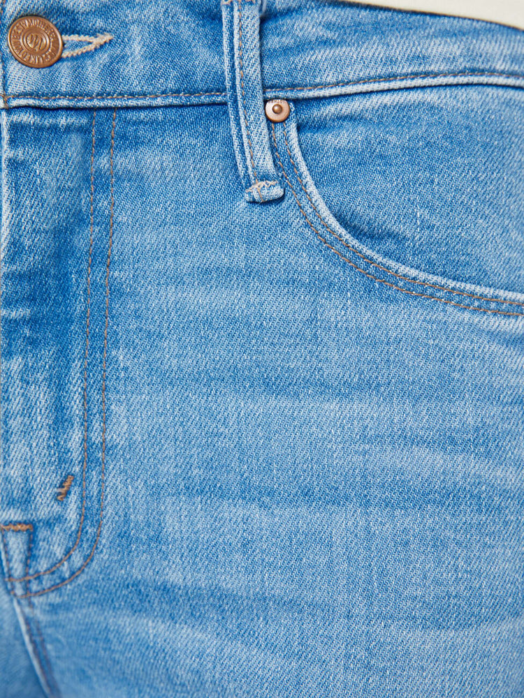 Swatch view of a woman in a light blue mid-rise flare has a zip fly, 31-inch inseam and a frayed hem.