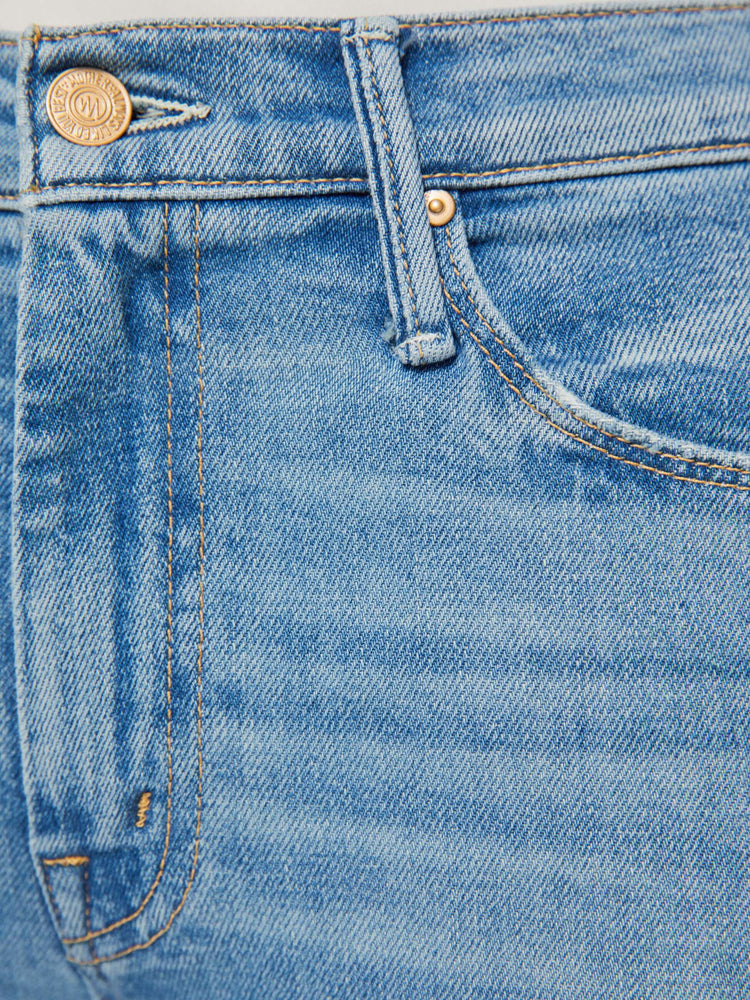 Swatch view of a woman in a vintage blue mid-rise flare has a zip fly, 31-inch inseam and a frayed hem.