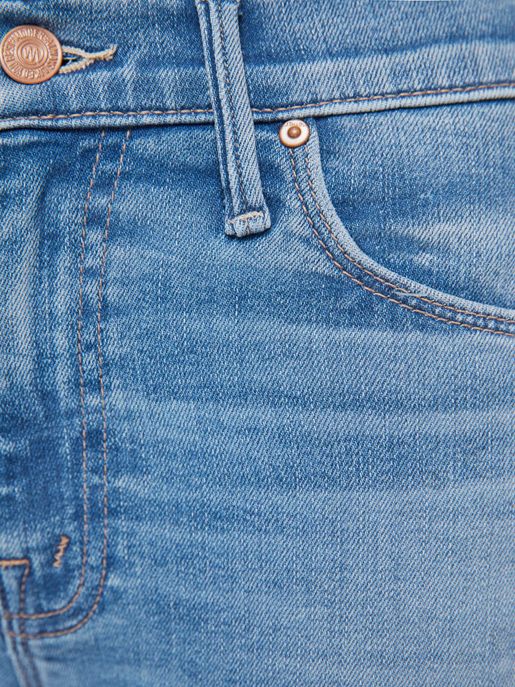 Swatch view of a woman in a light blue  mid-rise flare has a zip fly, 32.25-inch inseam and a frayed hem. 