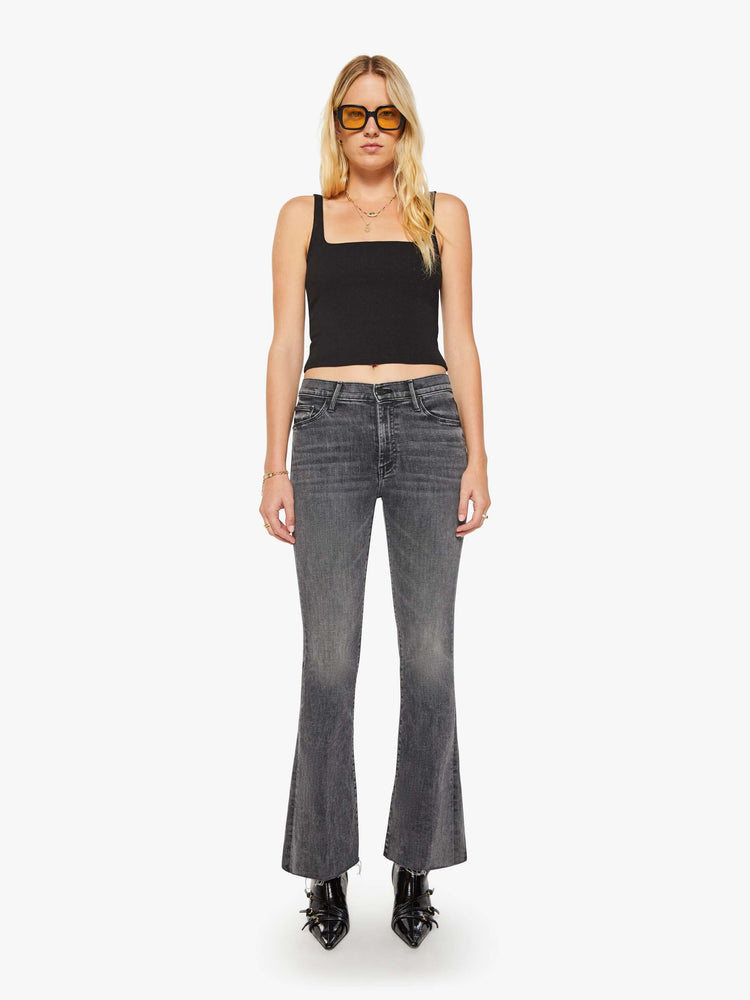 Front view of women's gray mid rise flare jean with zip fly and frayed hems.