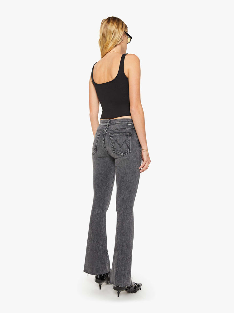 Back view of women's gray mid rise flare jean with zip fly and frayed hems.