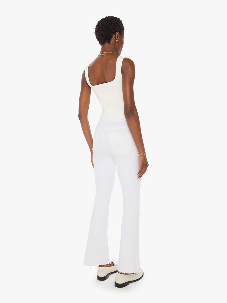 Back view of a womens white wash jean featuring a mid rise, flare leg, and a frayed hem.