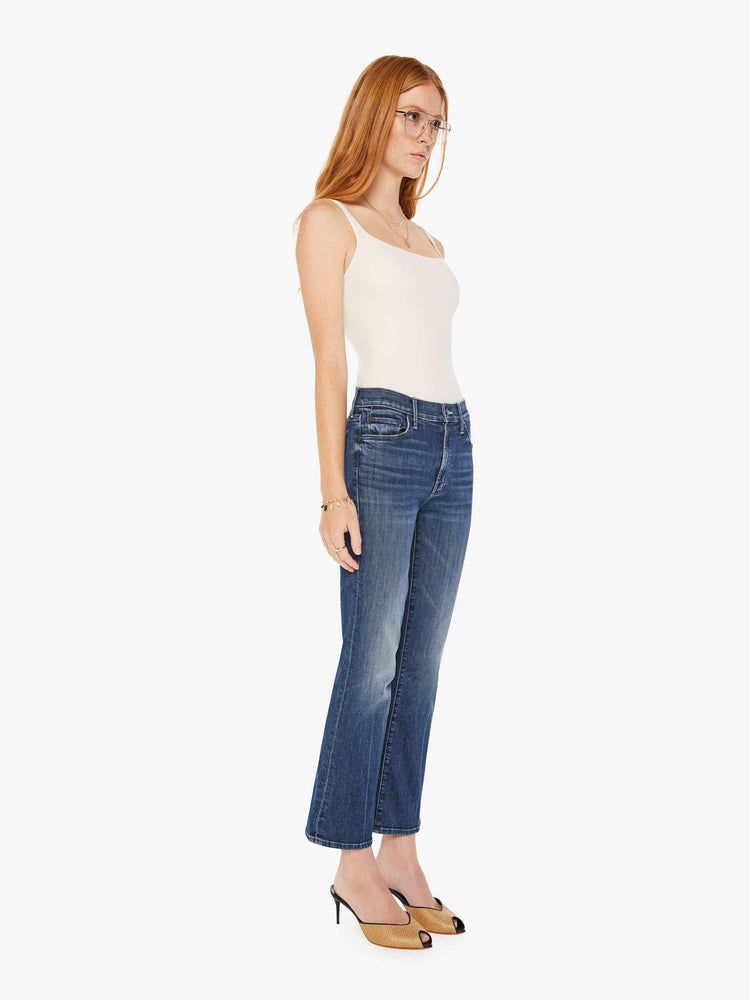 Front view of a womens dark denim wash jean featuring a mid rise and a ankle length flare.