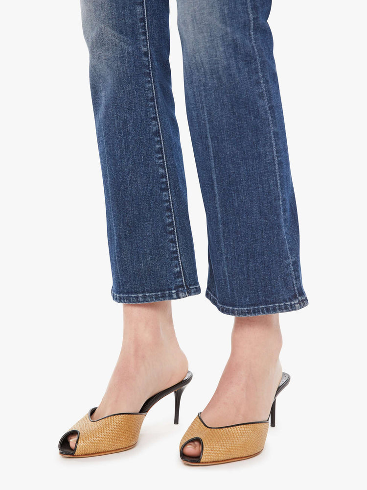 Front close up view of a womens dark denim wash jean featuring a mid rise and a ankle length flare.