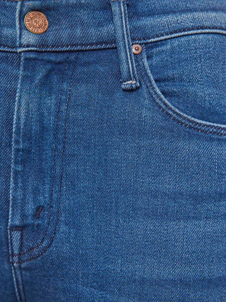 Swatch view of a woman in a med blue flare jean with a mid rise, zip fly, 31-inch inseam and a clean hem.