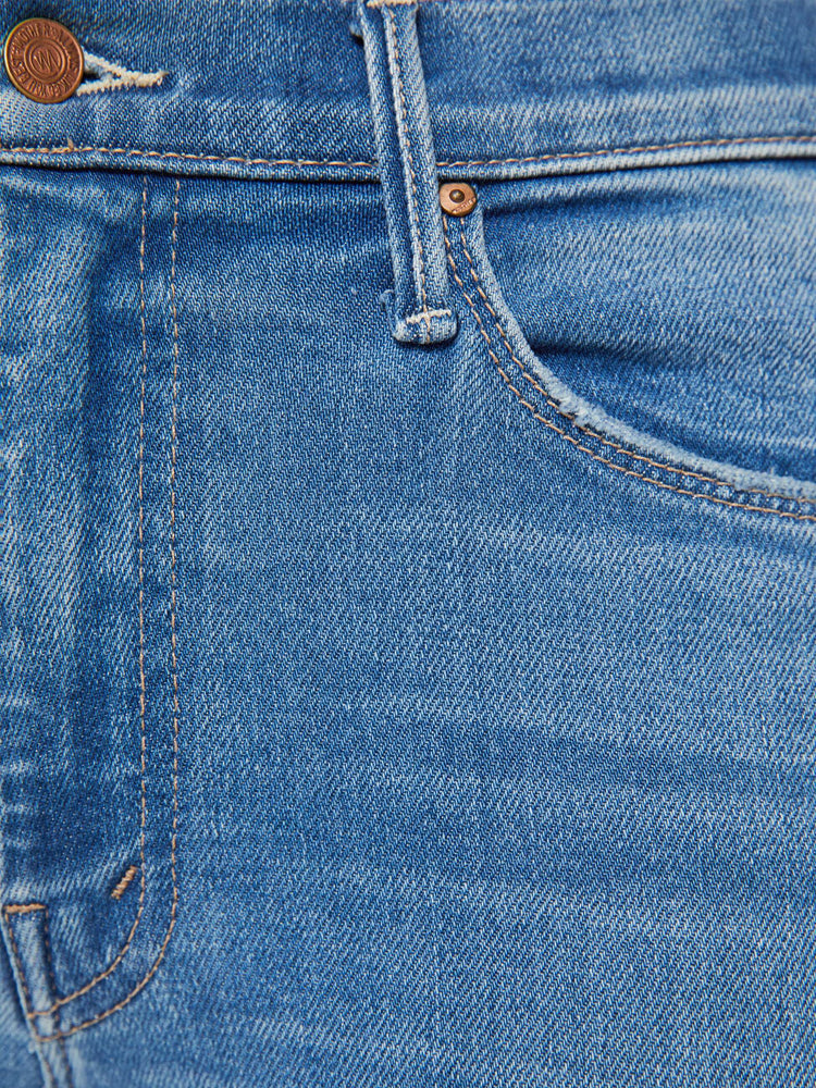 Swatch view of a woman in a blue flare mid rise with a 32.5-inch inseam and a clean hem.