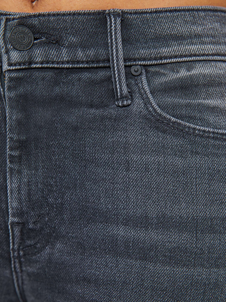 Swatch view of a woman in a faded black flare jean with a mid rise and 31-inch inseam and a clean hem. 