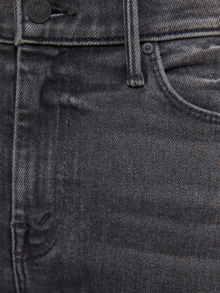 Swatch view of a woman in a faded black flare jean with a mid rise and 31-inch inseam and a clean hem. 