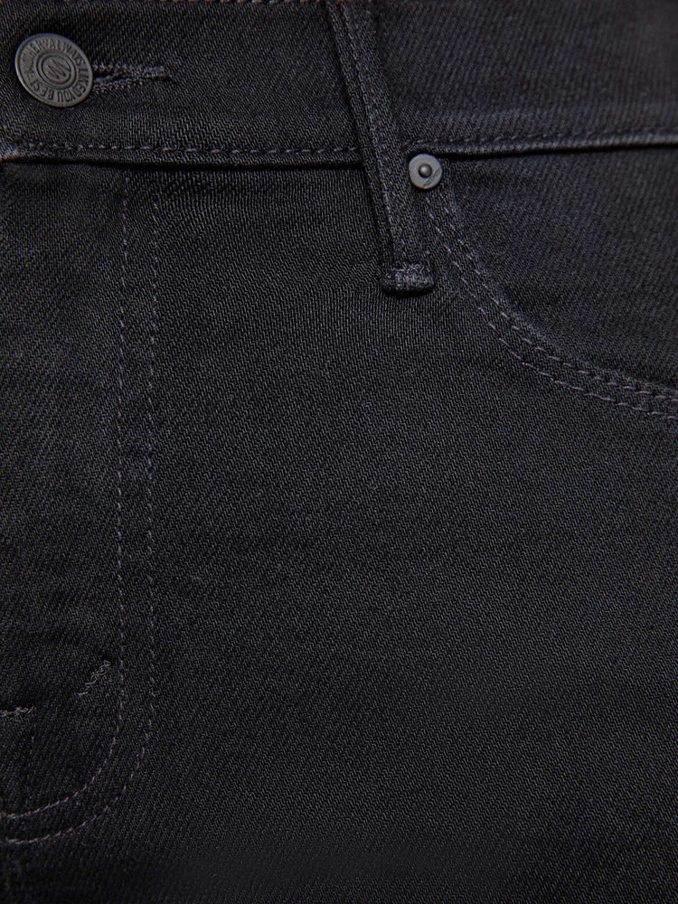 Swatch view of a woman in a dark black flare jean with a mid rise and 31-inch inseam and a clean hem. 