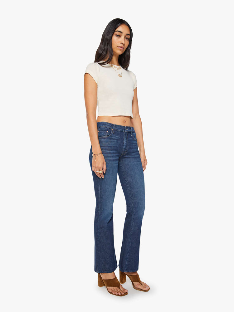 Side angle view of a dark blue mid rise jean with a 31-inch inseam and a clean hem.