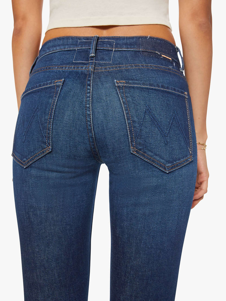 Close up view of a dark blue mid rise jean with a 31-inch inseam and a clean hem.