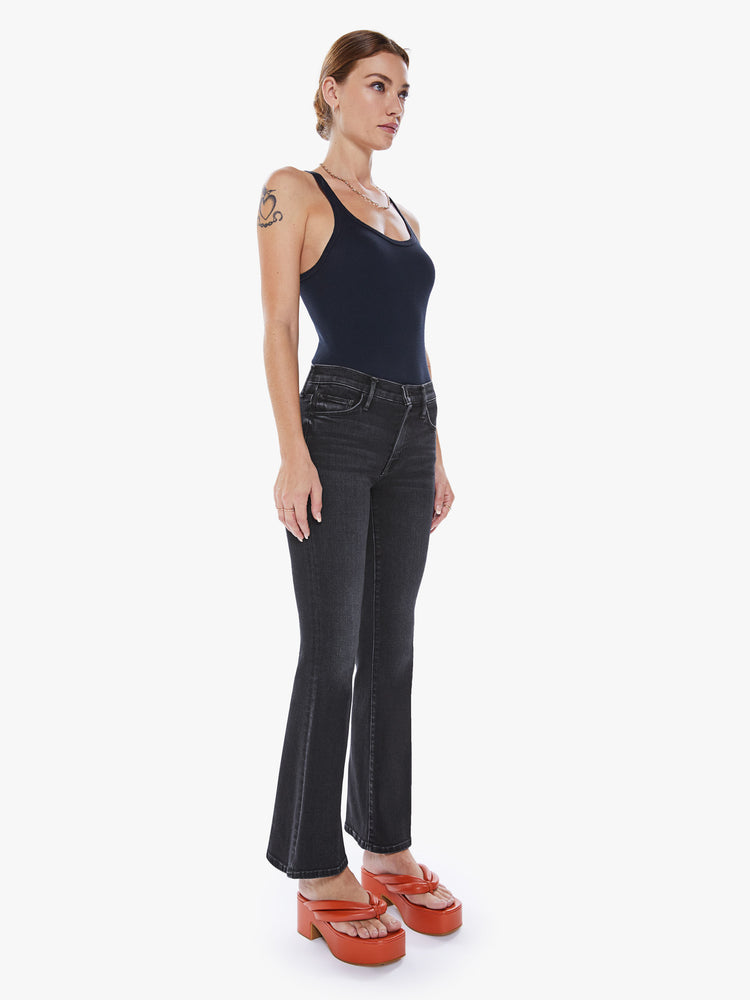 Front view of a woman flare jean has a mid rise with a 32 1/2-inch length inseam and a clean hem in a dark blue wash.
