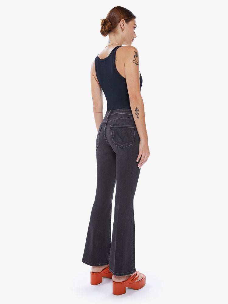 Back view of a woman flare jean has a mid rise with a 32 1/2-inch length inseam and a clean hem in a dark blue wash.