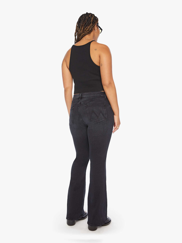 Back view of a woman flare jean has a mid rise with a 32 1/2-inch length inseam and a clean hem in a dark blue wash.