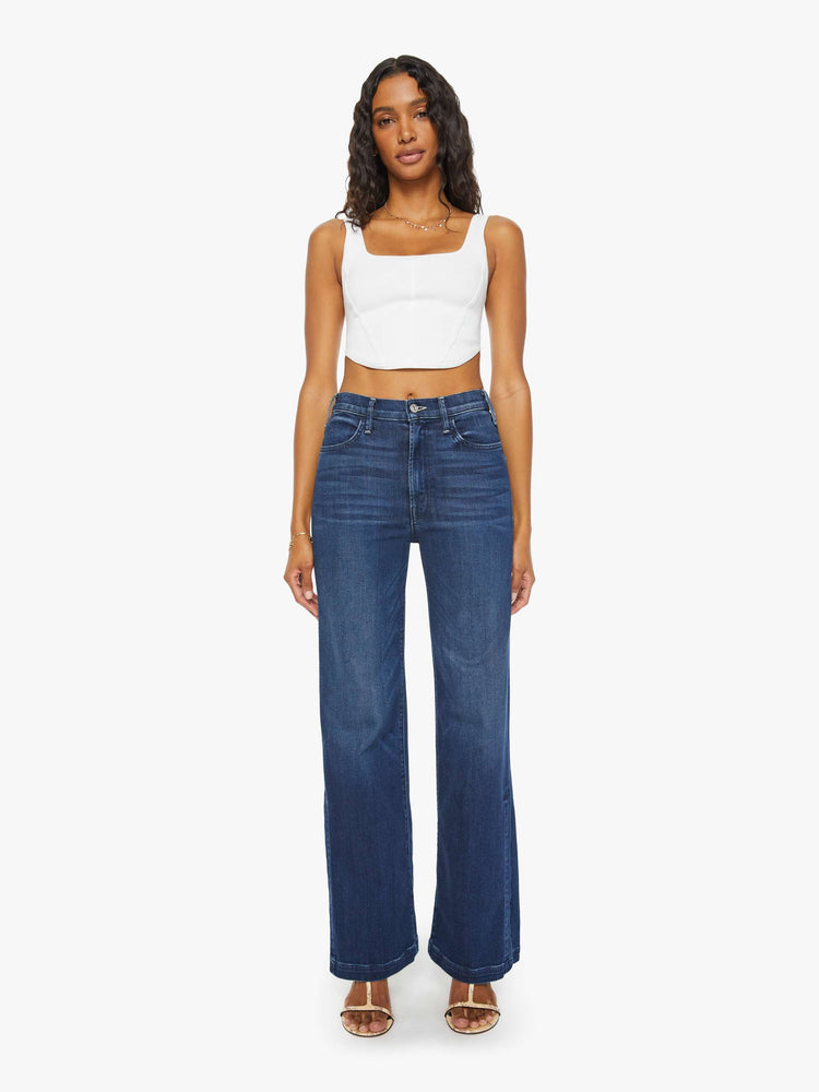 Front view of a woman high-waisted wide-leg jeans with a long inseam and a thick side-slit hem in a dark blue wash.