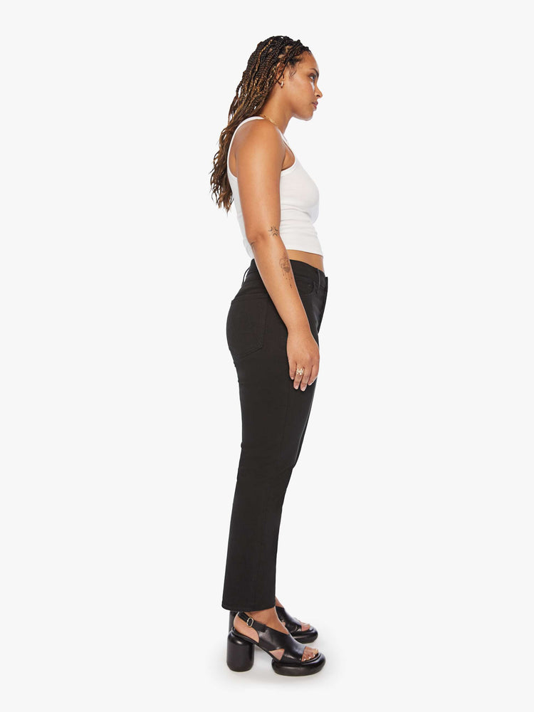 Side view of a women's black straight leg jean with a high rise and ankle length inseam