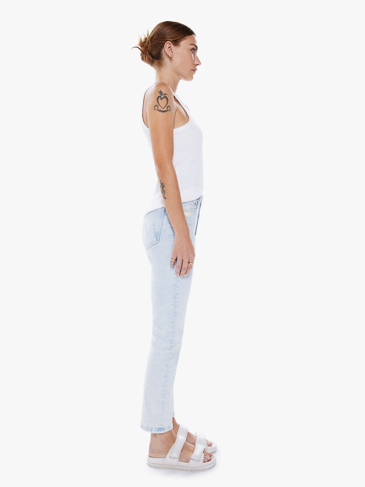 Side view of a women high-rise jean with a straight leg, button fly, ankle-length inseam and a clean hem in a light blue hue.