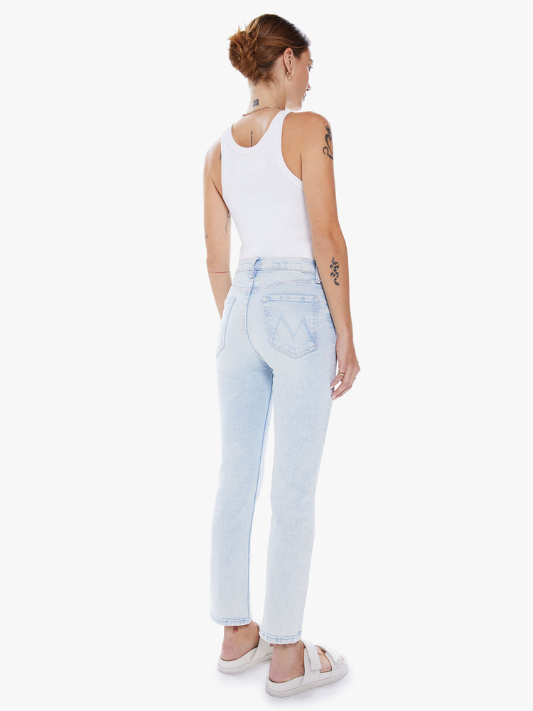 Back view of a women high-rise jean with a straight leg, button fly, ankle-length inseam and a clean hem in a light blue hue.