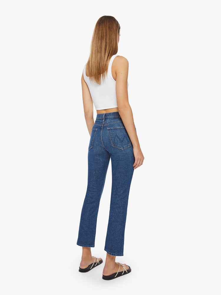 Back  view of a women's high-rise jean with a straight leg, button fly, ankle-length inseam and a clean hem in a dark blue wash.