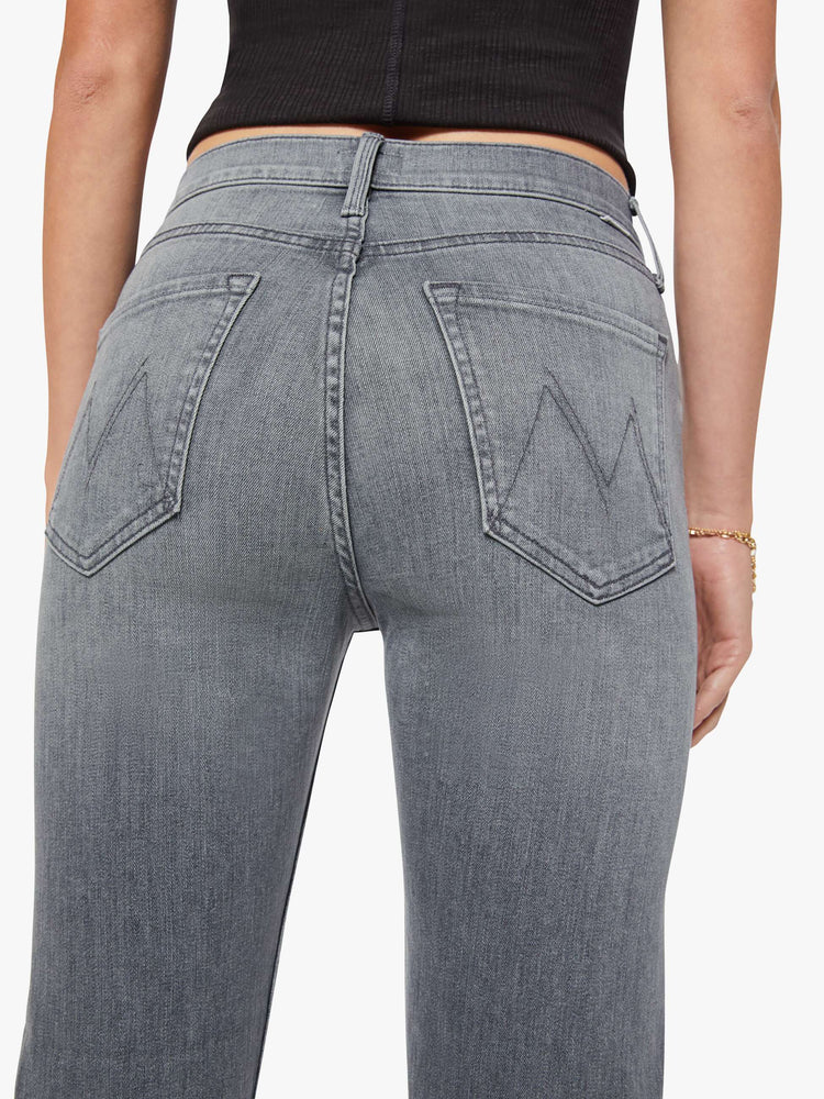 Close up view of a woman in a faded grey wash high-rise straight leg with a button fly and an ankle-length inseam. 