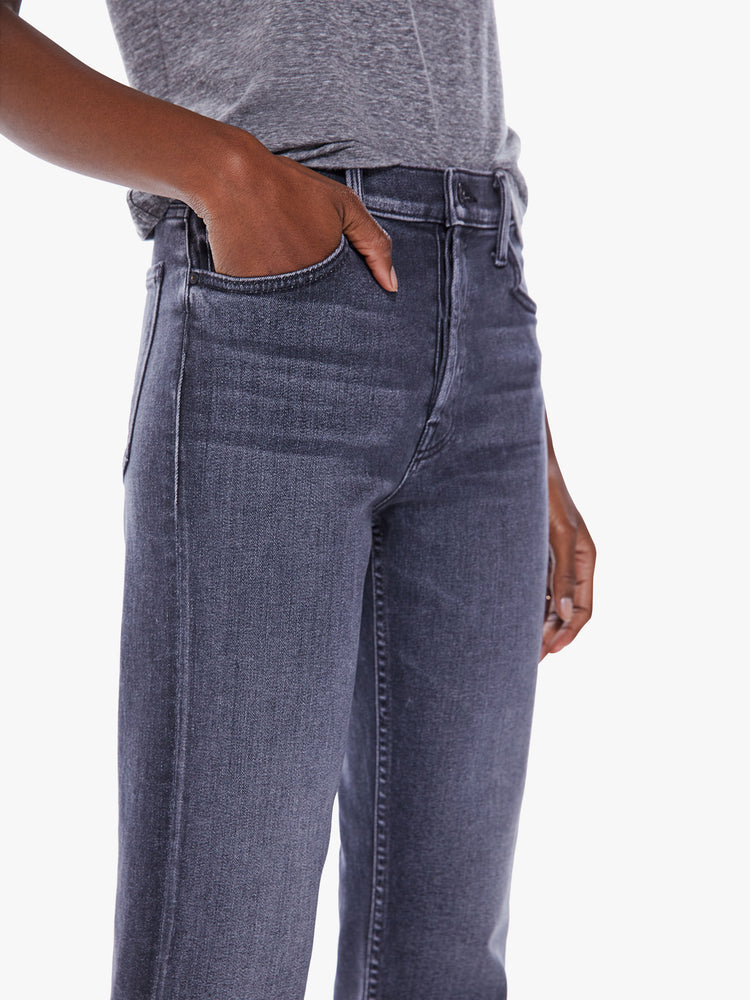 Close up view of a woman high-rise jeans with a straight leg, button fly, ankle-length inseam and a clean hem.