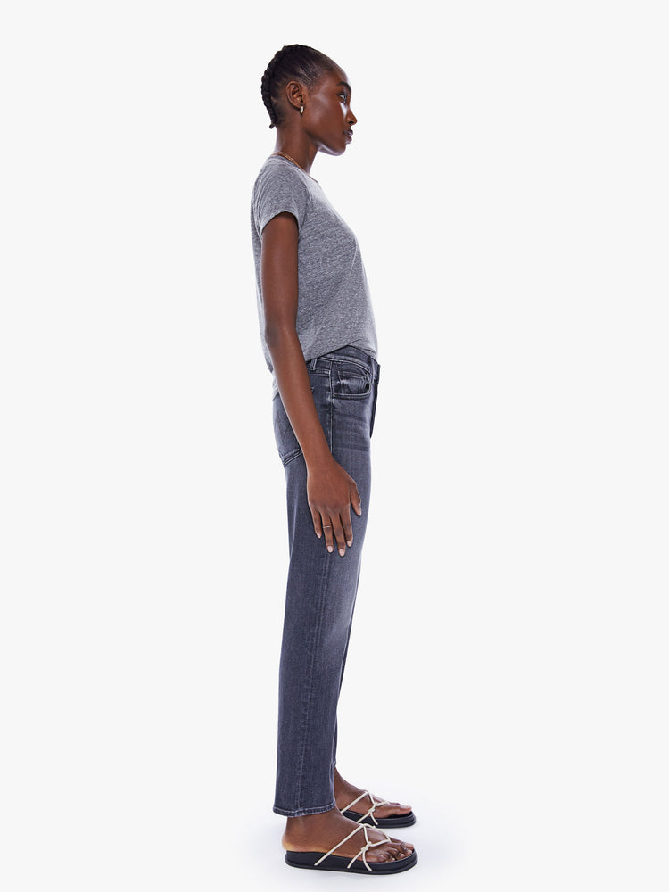 Side view of a woman high-rise jeans with a straight leg, button fly, ankle-length inseam and a clean hem.