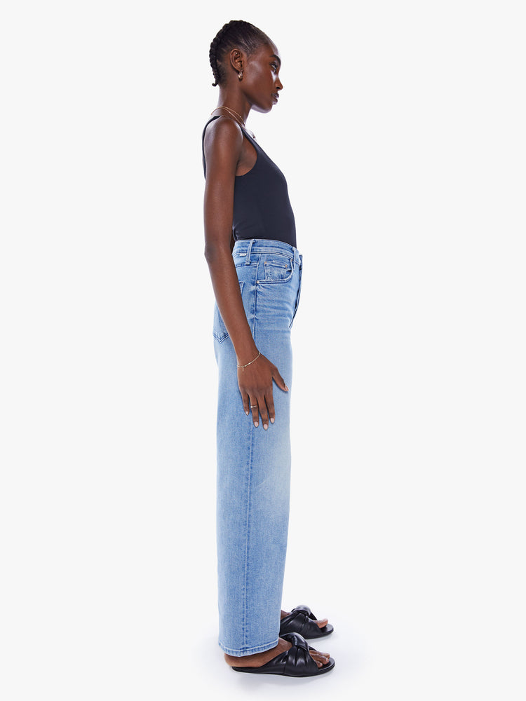 Side view of a woman's high-rise jeans with a loose wide leg, button fly and a 31-inch inseam with a clean hem in a light blue wash.