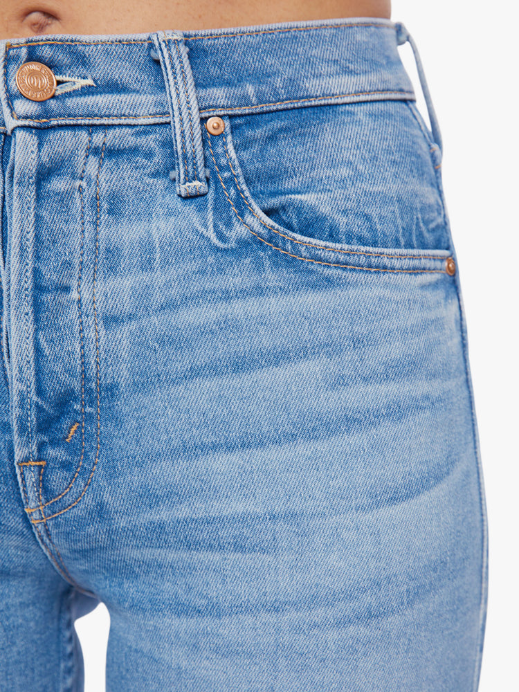 Swatch view of women med blue high-rise jeans with a straight leg, button fly, ankle-length inseam and a frayed hem.