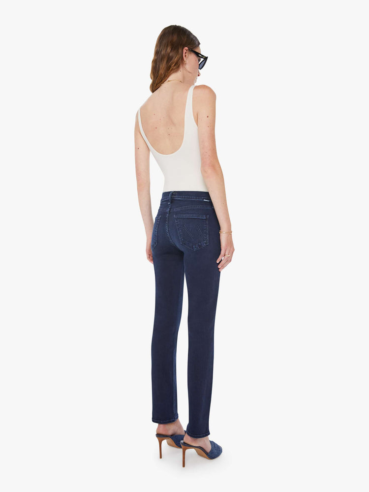 Back view of a woman in dark blue wash jeans with a mid-rise straight leg hits at the ankle with a clean hem.