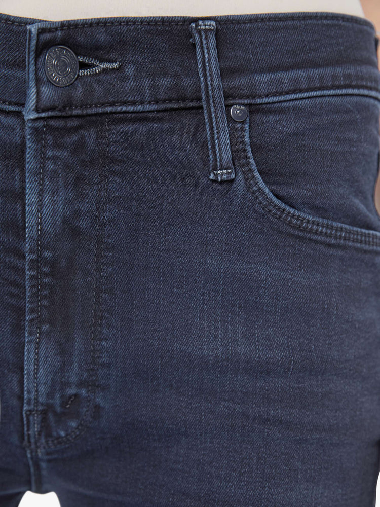 Close up view of a woman in dark blue wash jeans with a mid-rise straight leg hits at the ankle with a clean hem.
