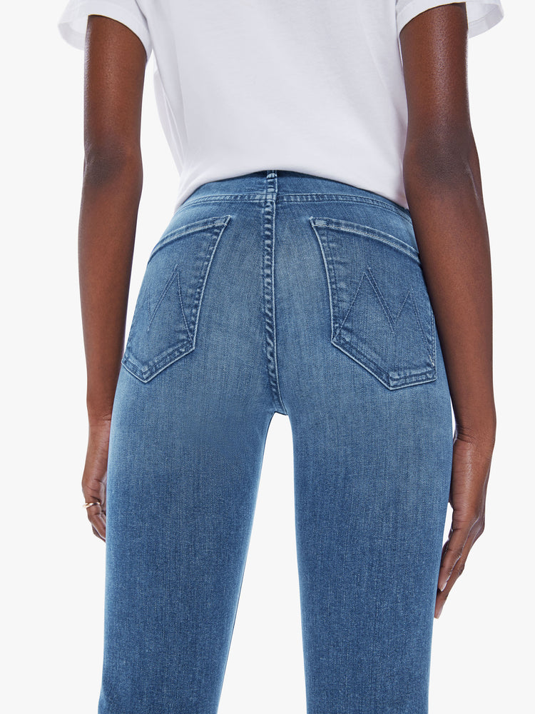 Back close up view of a womens medium blue wash jean featuring a mid rise, straight leg, and clean hem.