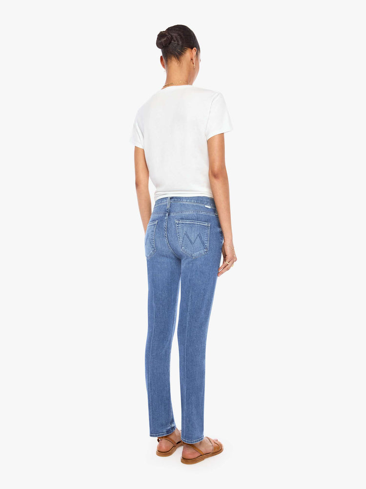 Back view of a womens classic medium blue wash denim jean featuring a mid rise, a slim straight leg, an ankle length clean hem, and subtle whiskering details.
