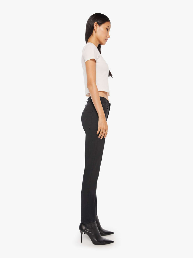 Side view of a woman a black mid-rise straight leg with an ankle-length inseam and a clean hem.