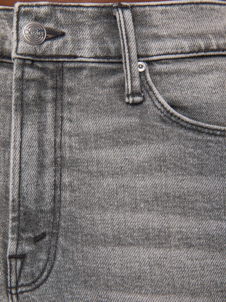 Swatch view of a woman in a mid-rise straight leg has a zip fly and hits at the ankle with a clean hem in a washed grey with whiskering and fading at the knees.