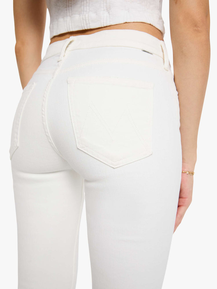 Back close up view of a woman wearing white denim jeans.