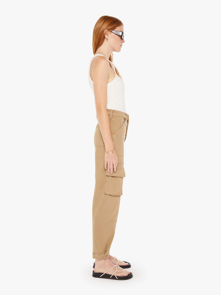 Side view of a womens brown cargo pants featuring a high rise and flood length hem.