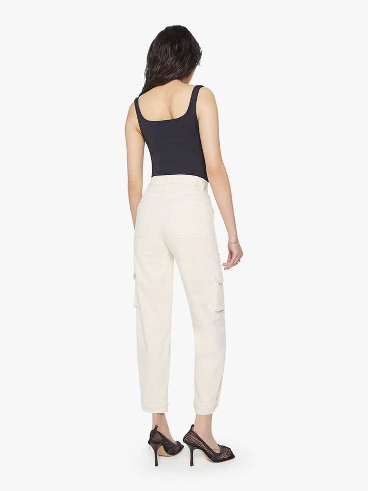 Back view of a woman super high waisted cargo pant with a barrel leg, patch pockets and a long inseam with snaps at the hem in an off-white color.