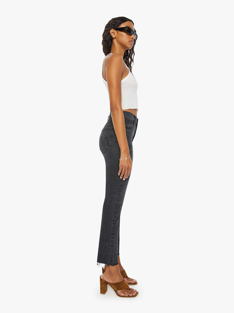 Side view of women's straight leg jean with exposed button fly in a faded black wash.