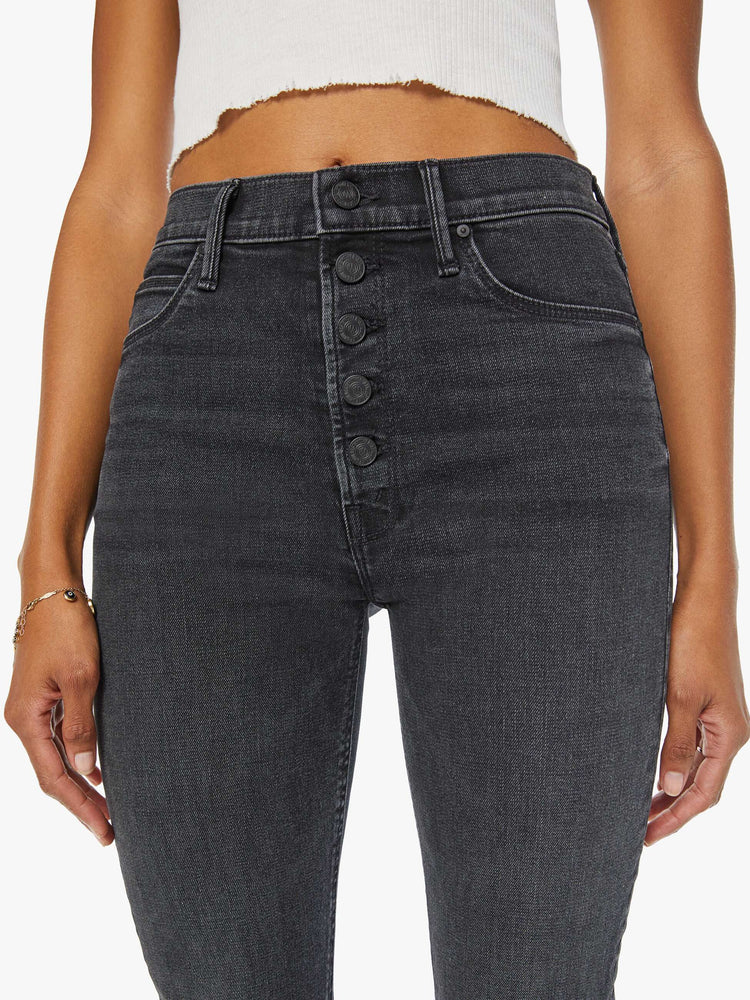 Waist close up view of women's straight leg jean with exposed button fly in a faded black wash.