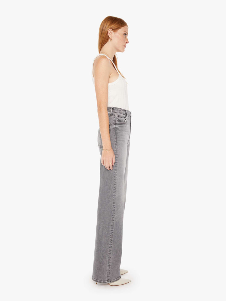 Side view of a grey wash jean featuring a super high rise, a wide leg, and full length clean hem.