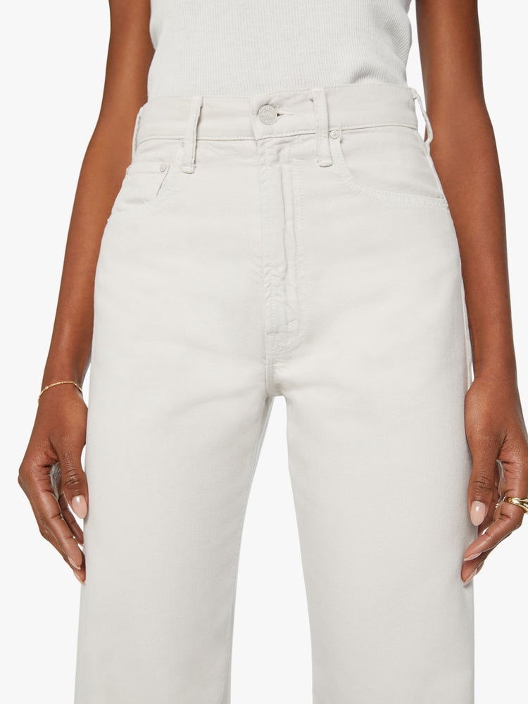 Waist view of a woman super wide-leg pants with a high rise and a long 34-inch inseam with a clean hem in an off white hue.