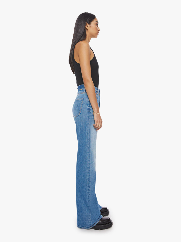 Side view of a woman classics blue super wide-leg jeans with a high rise and a long 34-inch inseam.