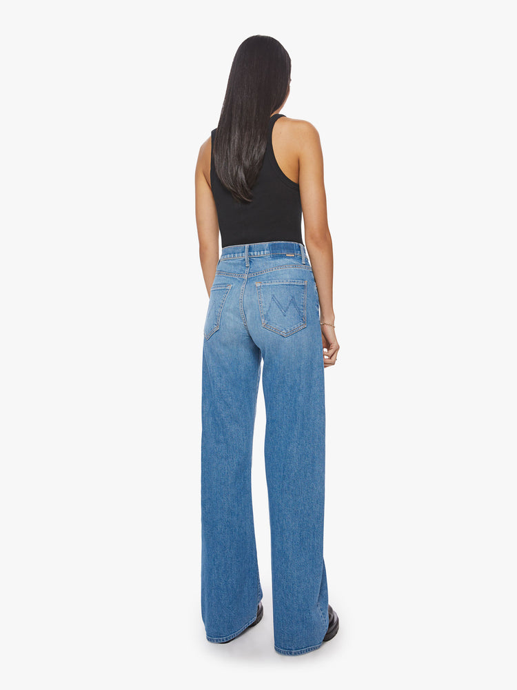 Back view of a woman classics blue super wide-leg jeans with a high rise and a long 34-inch inseam.