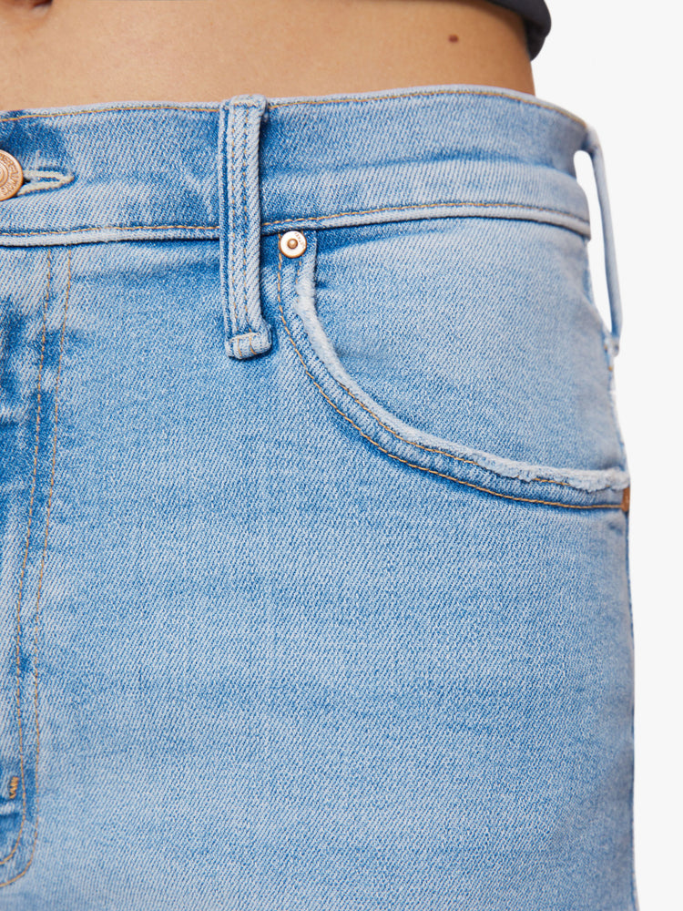 Front close up view of a woman high-waisted jeans with a loose wide leg and an ankle-length inseam in a light blue wash.