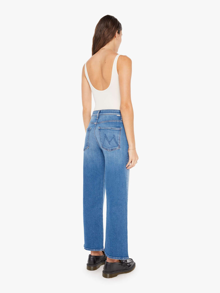 Back view of a woman igh-waisted jeans with a loose wide leg and an ankle-length inseam in a medium blue wash.