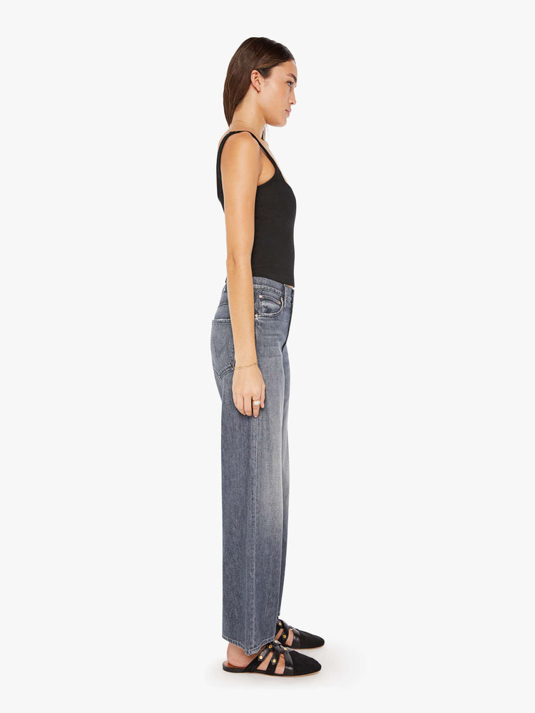 Side view of a womens grey wash jean featuring a slouchy mid rise fit, a wide leg, and a clean ankle length hem.