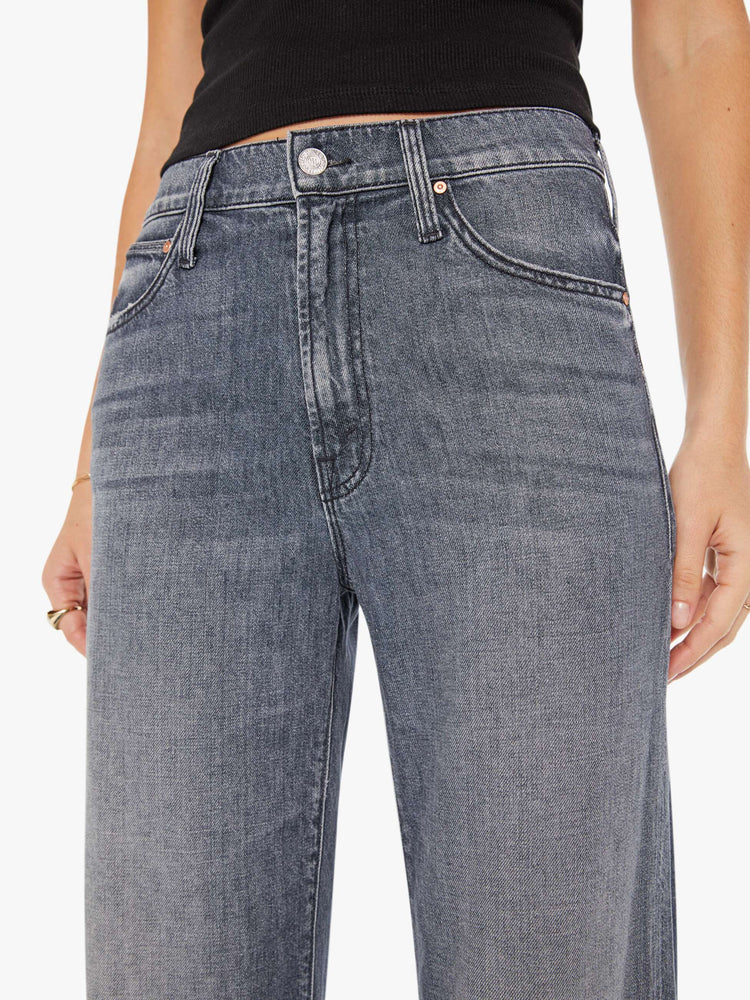 Front close up view of a womens grey wash jean featuring a slouchy mid rise fit, a wide leg, and a clean ankle length hem.