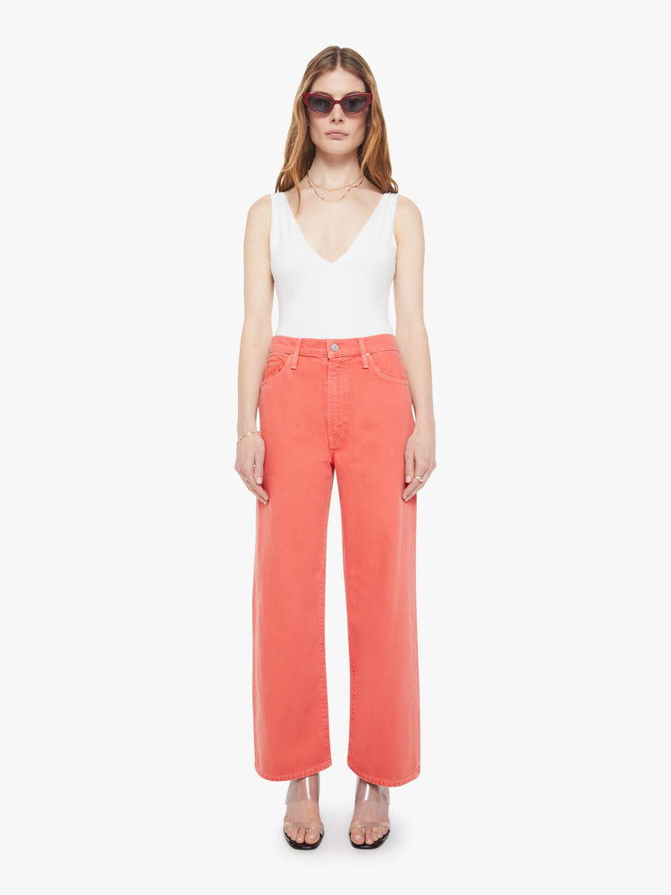 Front view of a woman in pants that sit lower on the hips with a zip fly, loose wide leg and a clean ankle-length inseam.