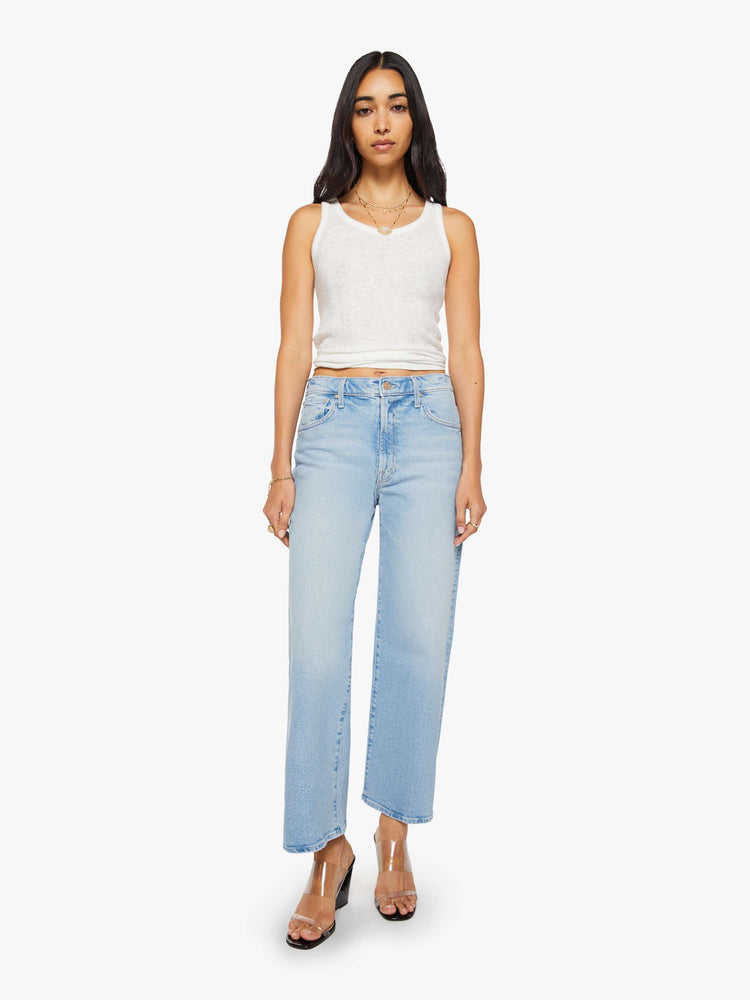 Front view of a woman in a light blue jeans designed to sit lower on the hips with a zip fly, loose straight leg and a clean ankle-length inseam.