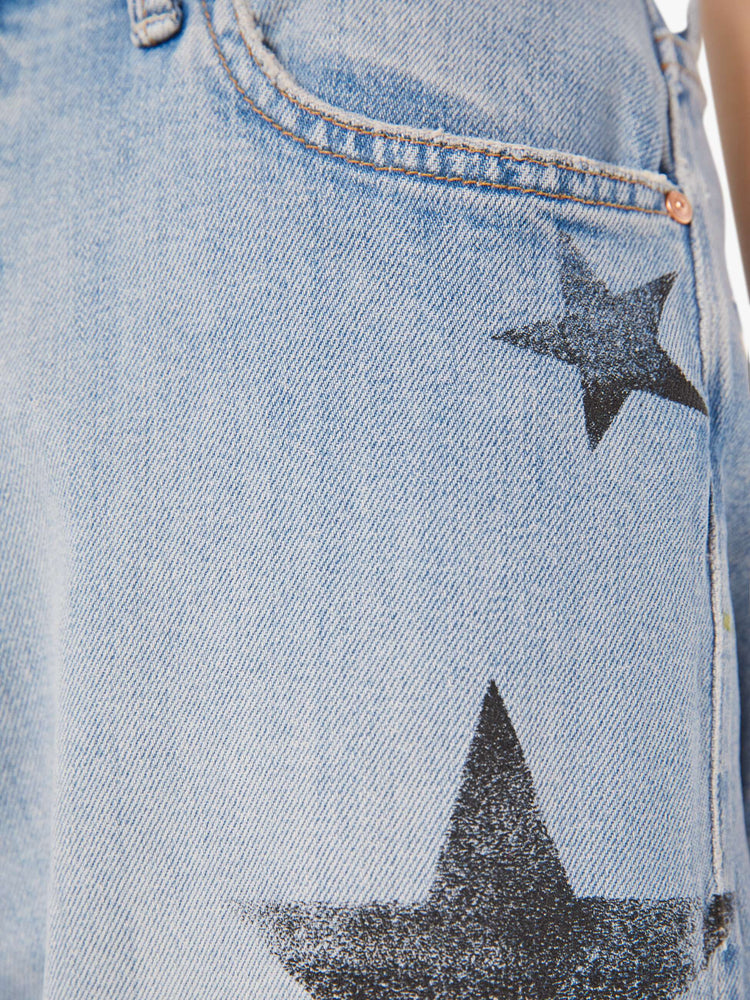 Swatch view of a woman in a light blue with faded stars through out jean with high-waisted jeans with a loose straight leg and an ankle-length inseam with a clean hem.